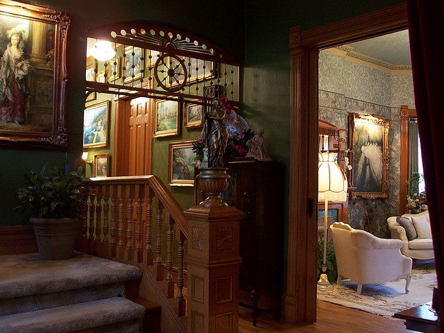 a staircase leading to a living room with paintings on the wall