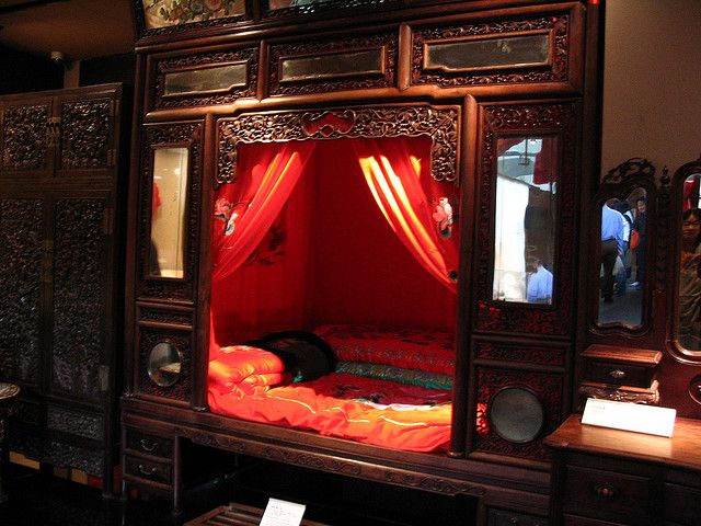 a room with a bed and red curtains