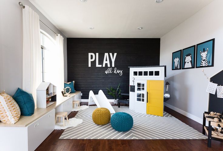 a play room with black walls and white furniture