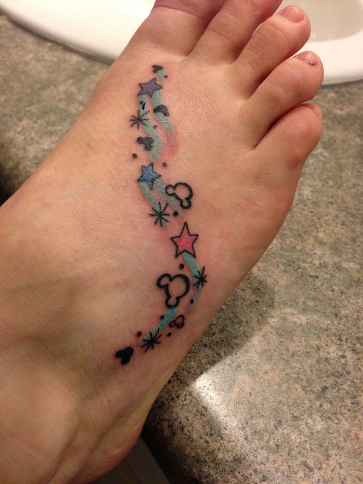 a person with a tattoo on their foot is standing in front of a white sink