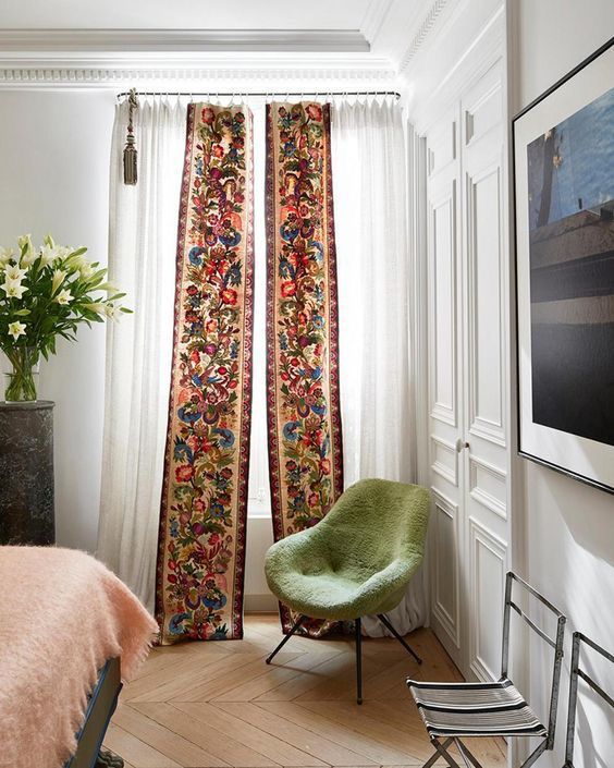 a green chair sitting next to a window in a bedroom