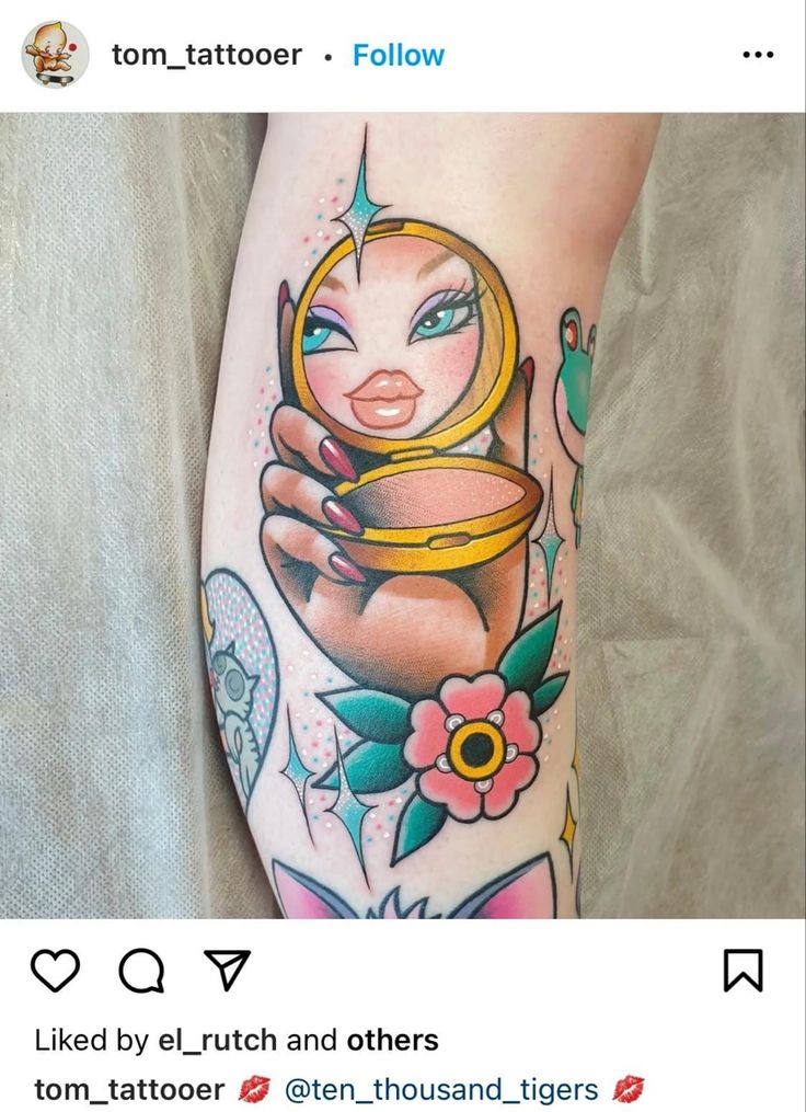 a woman's leg with tattoos on it and a cup in the middle of her leg