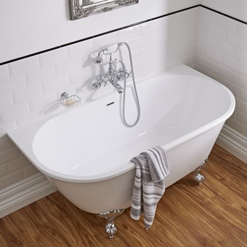 a white bath tub sitting on top of a hard wood floor next to a mirror