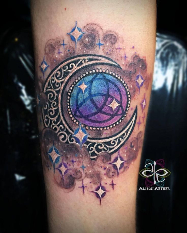 an artistic tattoo on the arm of a woman with stars and circles around her body