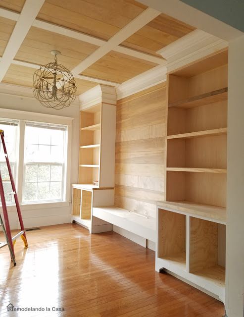 an empty room with wooden shelves and ladders