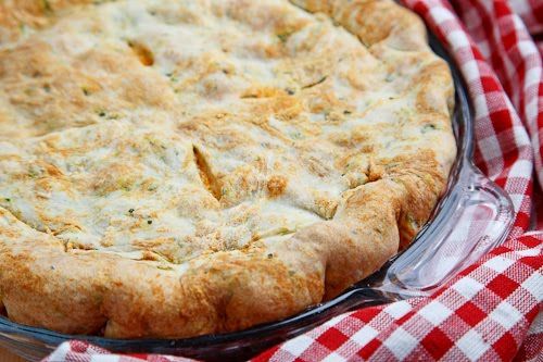 a cheesy dish is sitting on a red and white checkered cloth