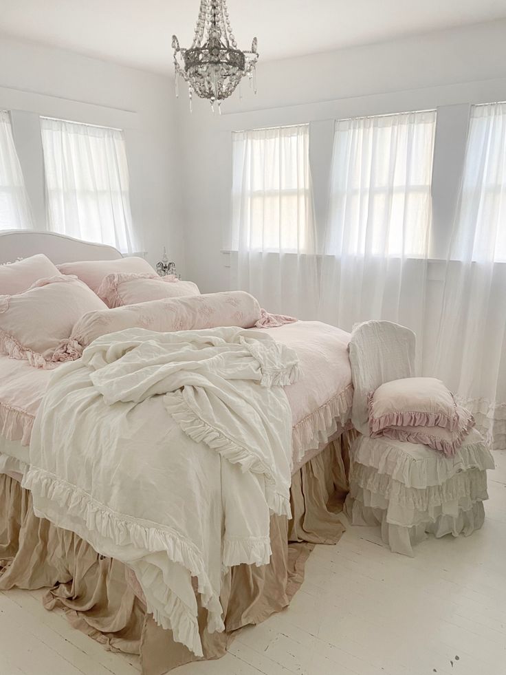 a bed with ruffled bedspread and two chairs