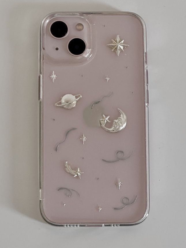 an iphone case with stars, moon and planets on the back is shown in clear plastic