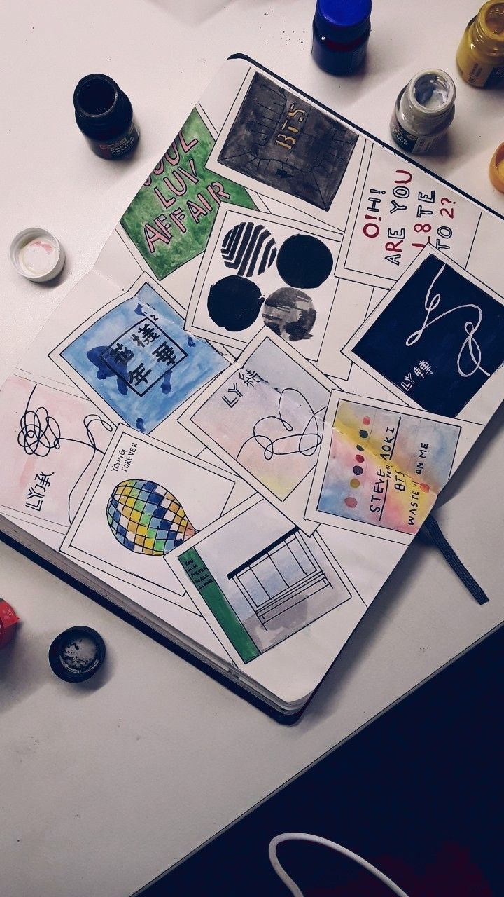 an open notebook with various stickers and pens on it next to some other items