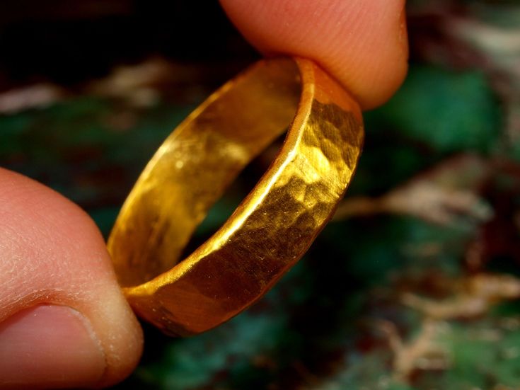 "This is a solid gold ring constructed using pure 24k gold. I start with refined .999 pure gold and melt it to red hot liquid metal, then forge it into a bar which is painstakingly rolled and hammered into the finished ring you see. The brilliance of pure 24k (99.9% gold content) gold is unmistakable. The rich color stands out from most standard jewelry that is made from 14k (58.3% gold content) and 18k (75% gold content) jewelry. The band is approximately 6mm wide and 1.1mm thick. Weights vary Gold Hand Forged Jewelry With Thick Band, Hand Forged Gold Jewelry With Thick Band, Gold Hand Forged Round Band Rings, Hand Forged Gold Engraved Promise Ring, Gold Hand Forged Ring With Thick Band, Gold Rings With Hand Forged Thick Band, Hand Forged Gold Ring With Thick Band, Ceremonial Hammered Yellow Gold Jewelry, Gold Hammered Engraved Ring For Promise