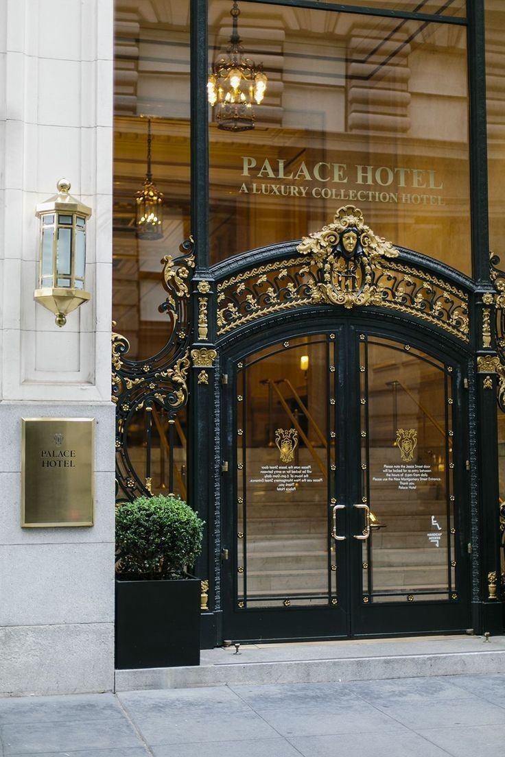 the entrance to palace hotel is decorated with gold and black accents, along with potted plants