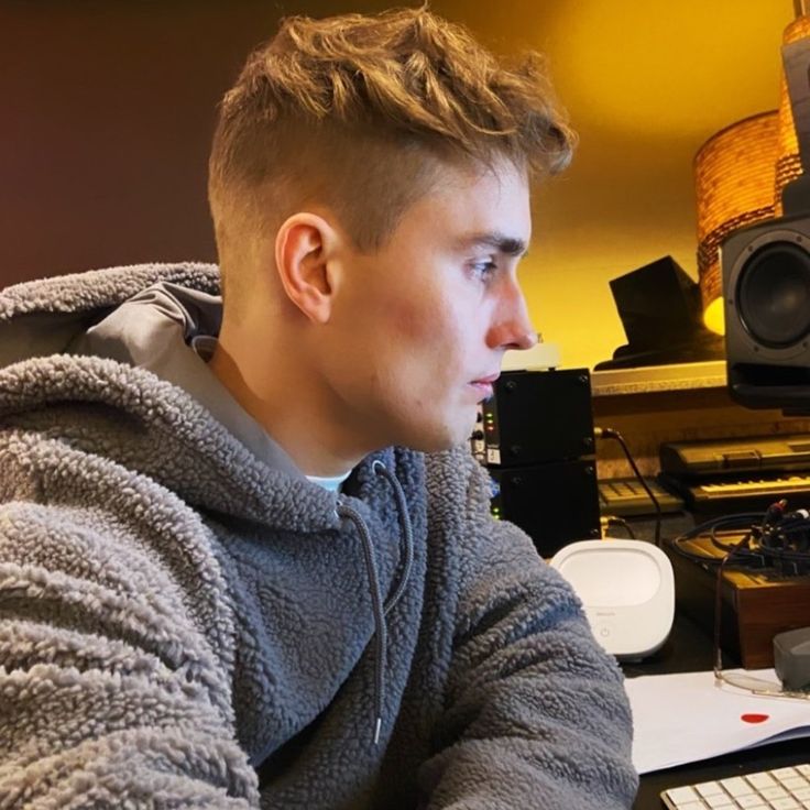 a young man sitting in front of a laptop computer