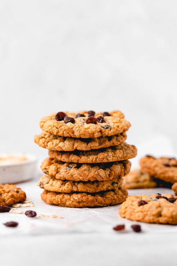 a stack of cookies with raisins and chocolate chips next to it on a white surface