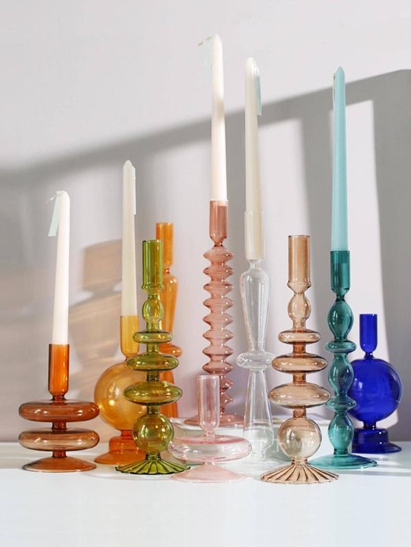 there are many different colored candles on the table