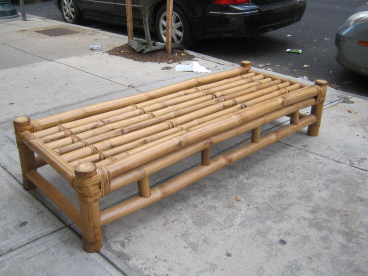 a bed made out of bamboo sitting on the sidewalk