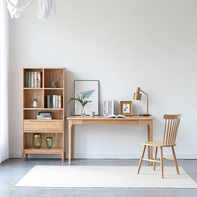 a wooden desk sitting next to a book shelf on top of a white carpeted floor