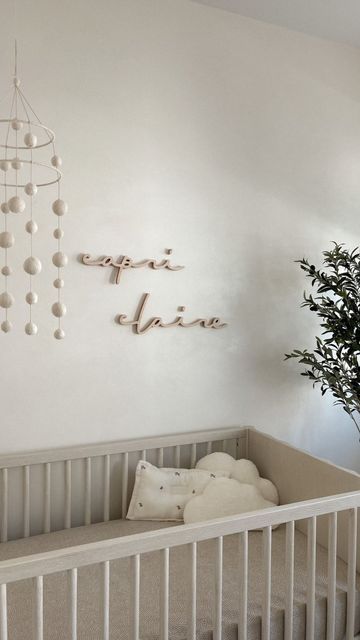 a baby crib in a white room with a potted plant