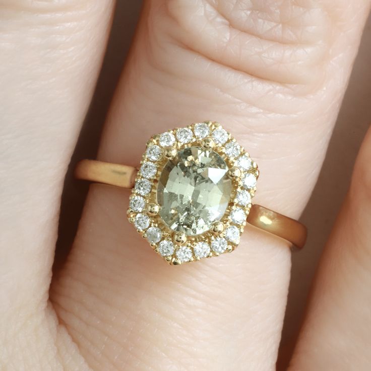 a close up of a person's hand with a diamond ring on their finger