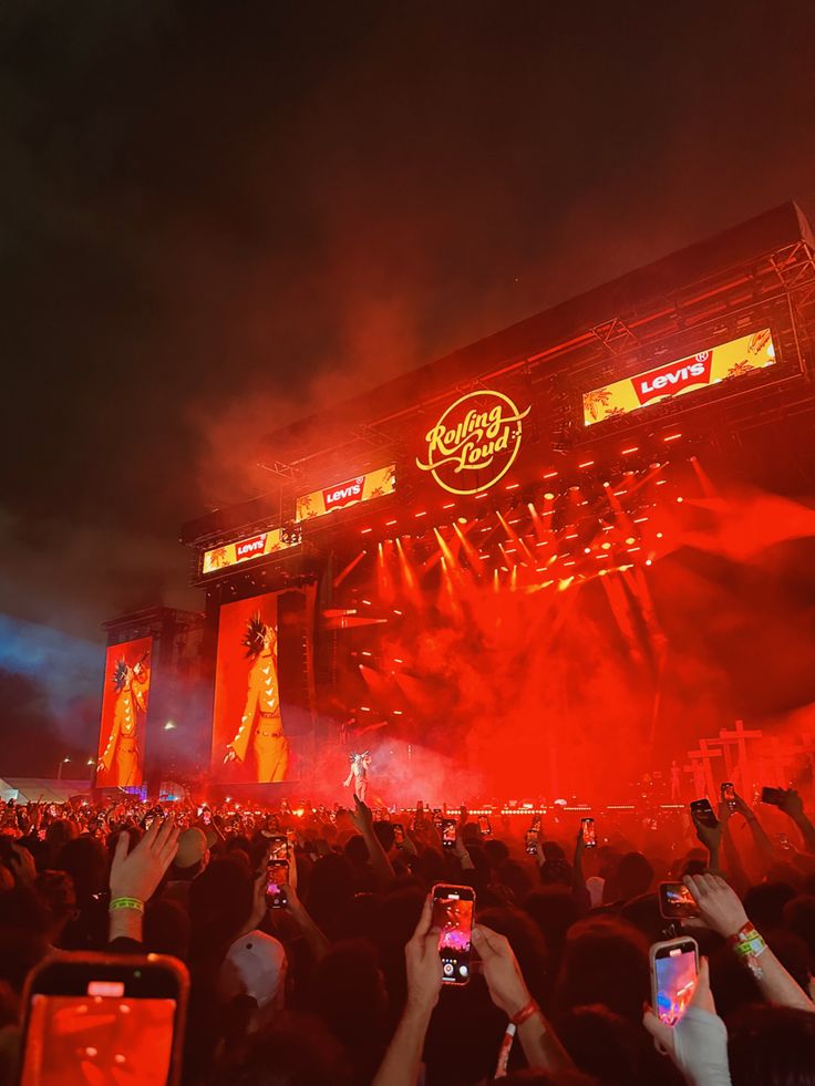 the crowd is taking pictures with their cell phones at an outdoor music festival on stage