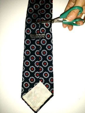 a person holding scissors over a tie on a white surface with red and blue circles