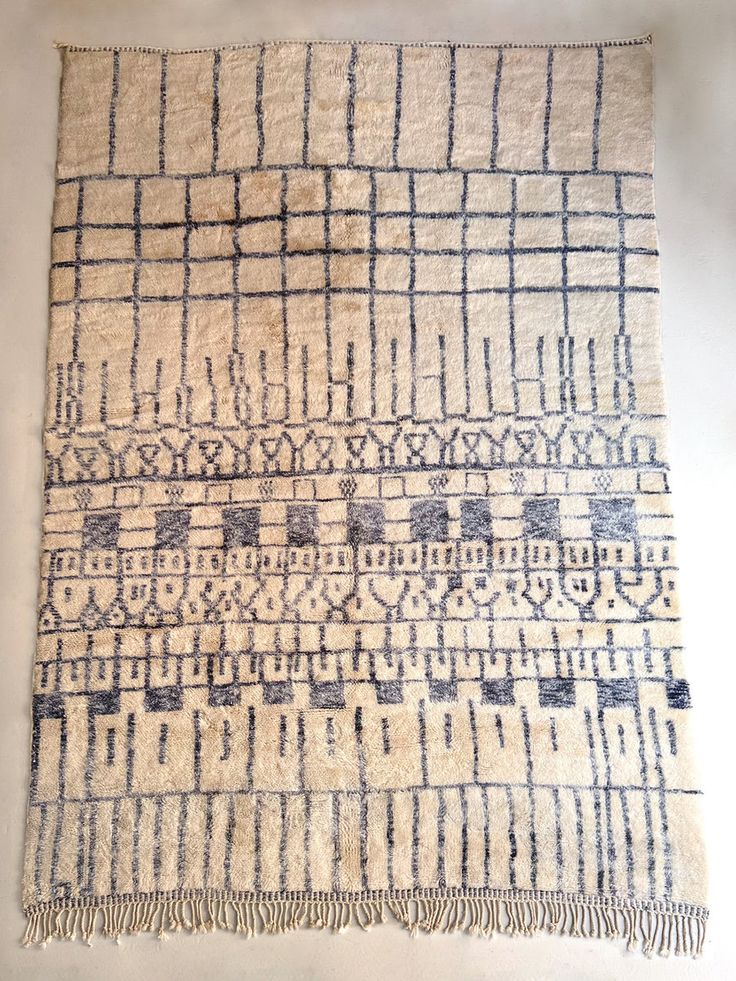 an old rug with blue and white designs on the side, sitting on a table