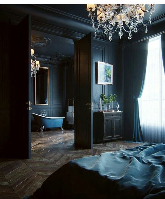 a bedroom with a chandelier, bed and bathtub in the middle of it