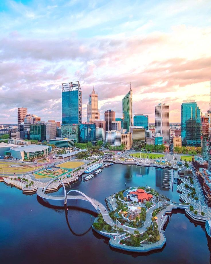 an aerial view of a large city with lots of tall buildings and water in the foreground