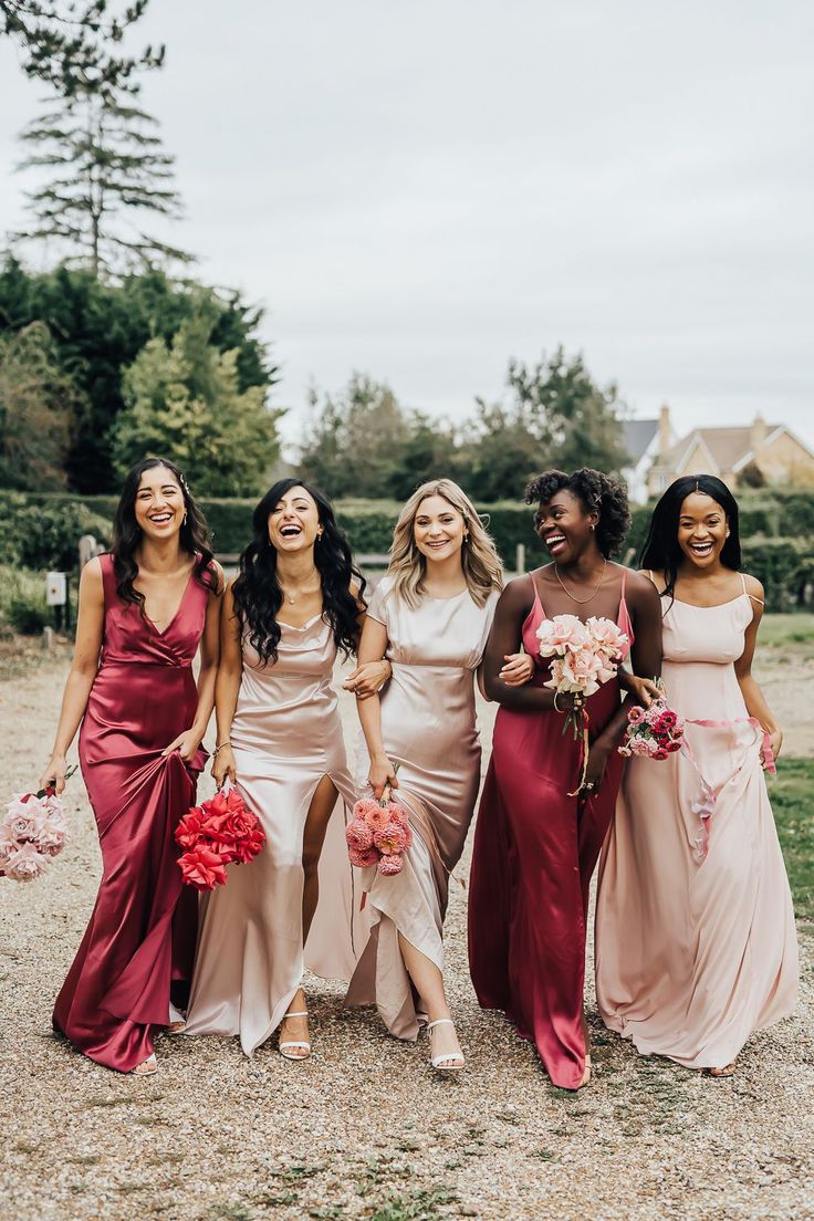 the bridesmaids are all dressed in different colors and styles, posing for a photo