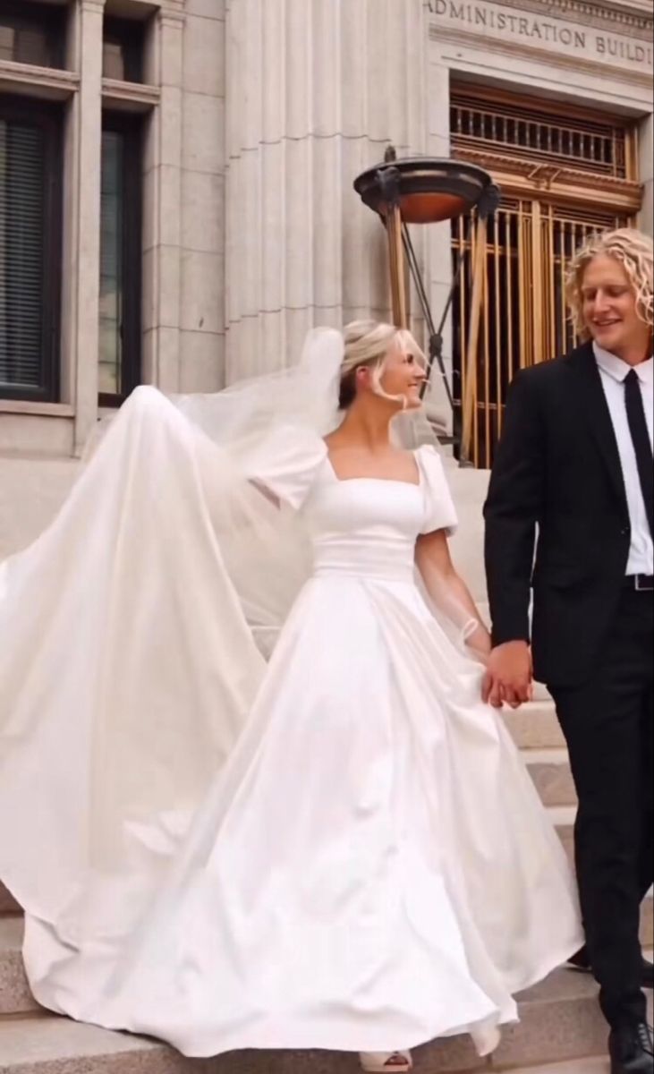 a bride and groom are walking down the steps