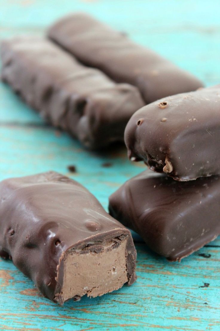 three pieces of chocolate candy sitting on top of a blue wooden table next to each other