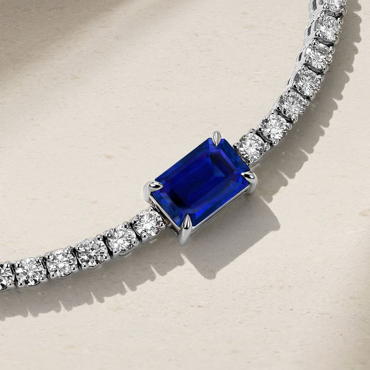 Simple elegance with a modern twist, our Nouveau Tennis Bracelet is strung with a row of twinkling petite diamonds that lead to a captivating emerald cut royal blue sapphire that rest at the center. Everyday luxury is made easy with this captivating bracelet that sparkles from every angle and exudes your strong sense of refined style. Wear it alongside your watch or layer it with a stack of delicate bracelets. Metal: 18kt Gold Sapphire Weight: 1.35 ct. Diamond Weight: 2.95 ct. Measurements: 7.0" length *Please note that the listed ct. weights are approximate and may be subject to slight variations. Luxury Blue Sapphire Tennis Bracelet, Emerald Cut Tennis Bracelet With Diamond Accents, Emerald Cut Diamond Accents Tennis Bracelet, Timeless Sapphire Jewelry With Radiant Cut, Classic Emerald Cut Jubilee Bracelet, Timeless White Gold Lab-created Sapphire Jewelry, Elegant Blue Emerald-cut Jewelry, Fine Jewelry Emerald Cut Diamond Bracelet In White Gold, Timeless Sapphire Jewelry With Diamond Accents