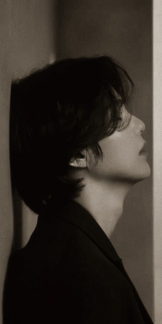 a black and white photo of a mannequin's head with dark hair