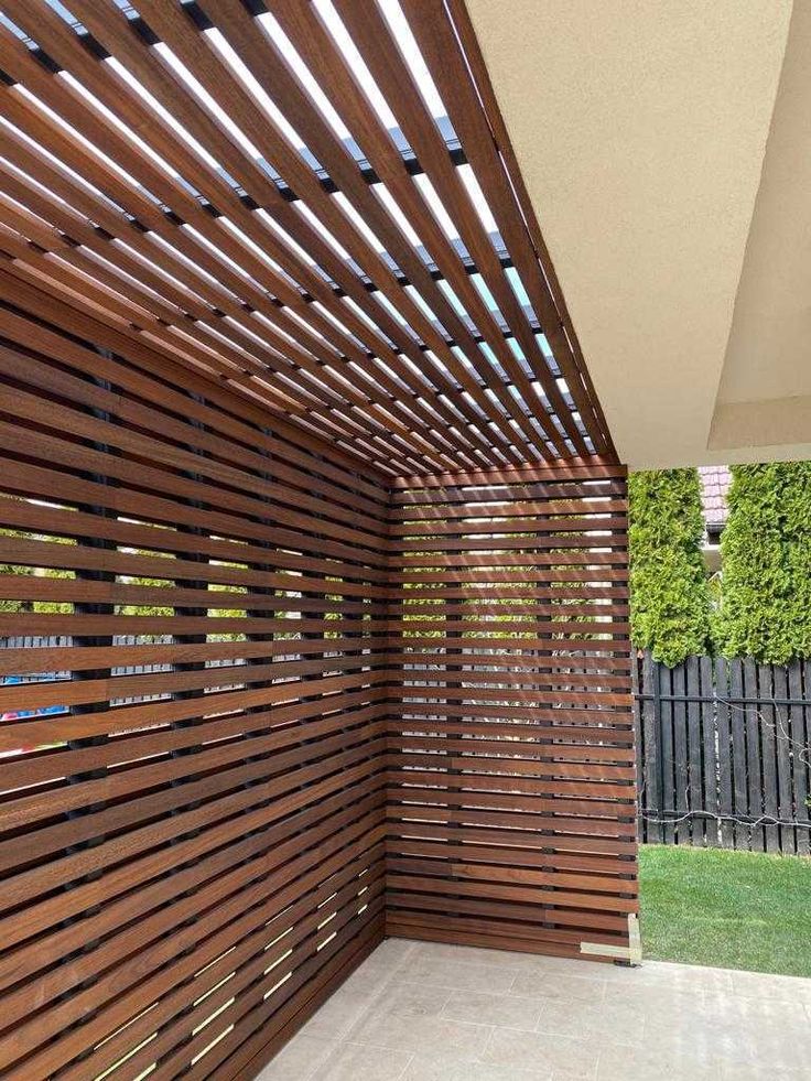 an outdoor room with wooden slats on the wall