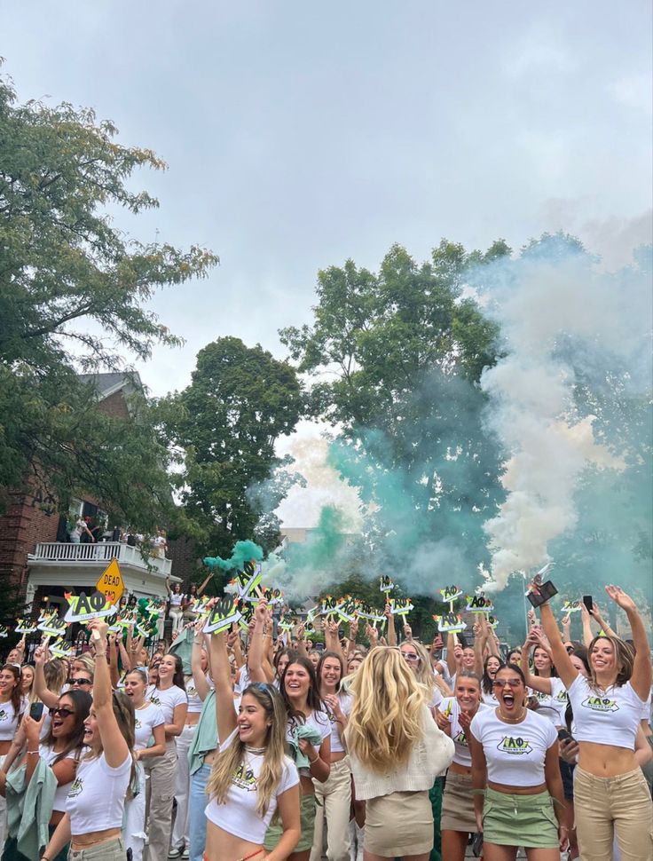 a group of people standing around each other holding up green and white confetti