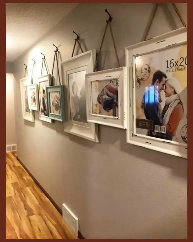 there are pictures hanging on the wall in this hallway, along with other framed photos