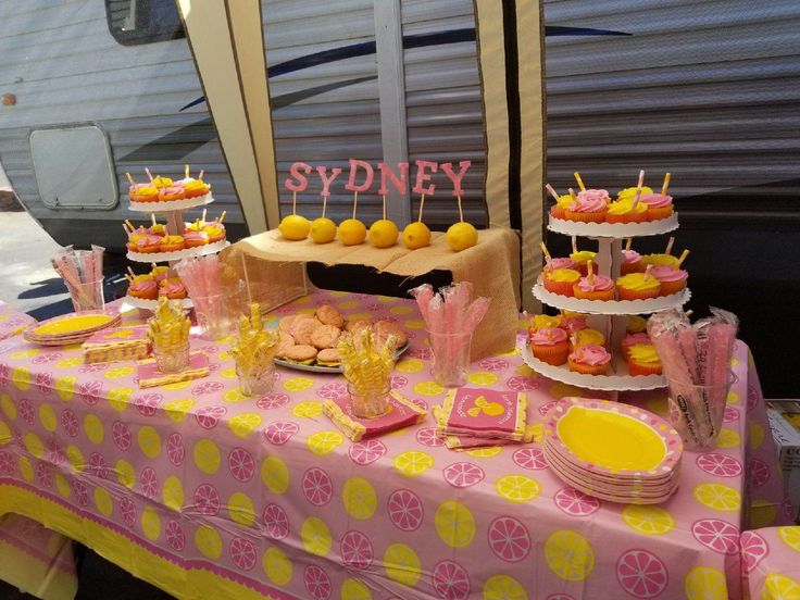 a table topped with lots of yellow and pink desserts