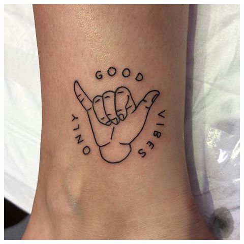 a small foot tattoo with two fists on it