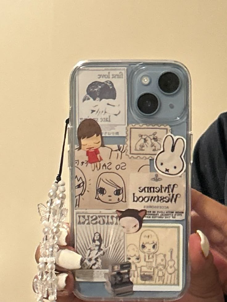 a person holding up a cell phone case with stickers on the back and sides