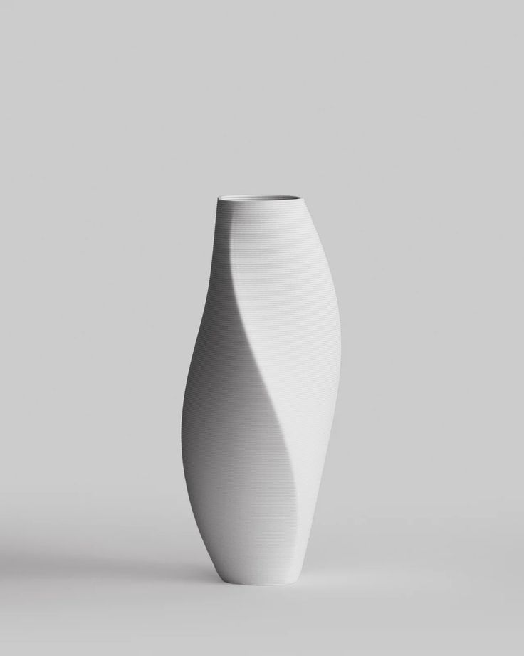 a white vase sitting on top of a table