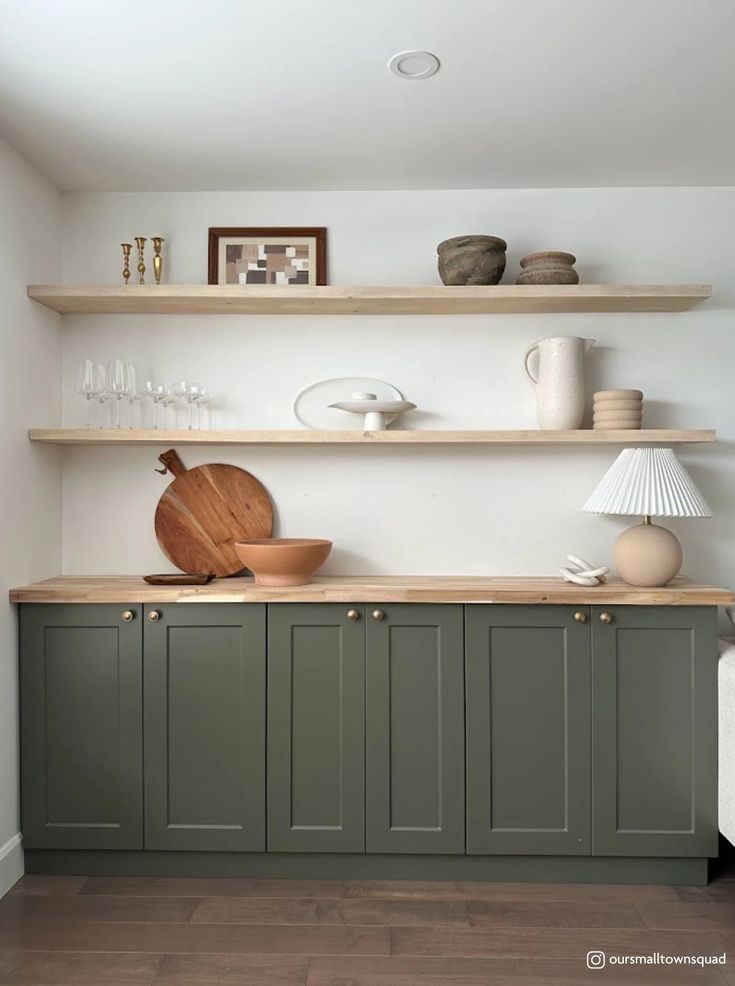 a kitchen with green cabinets and white walls