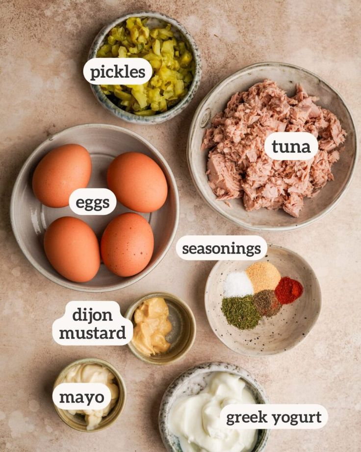 an image of eggs and other ingredients in bowls on a table with the words pickles, tuna, seasonings, mayo, green yogurt