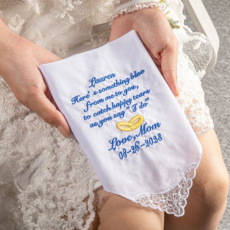 a woman is holding a handkerchief with the words i love you mom written on it