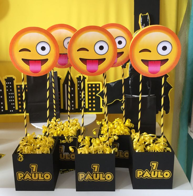 some black boxes with yellow candies in them and one has an emoticive face on it