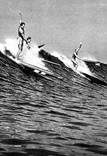 three people on surfboards riding waves in the ocean with one person falling off his board