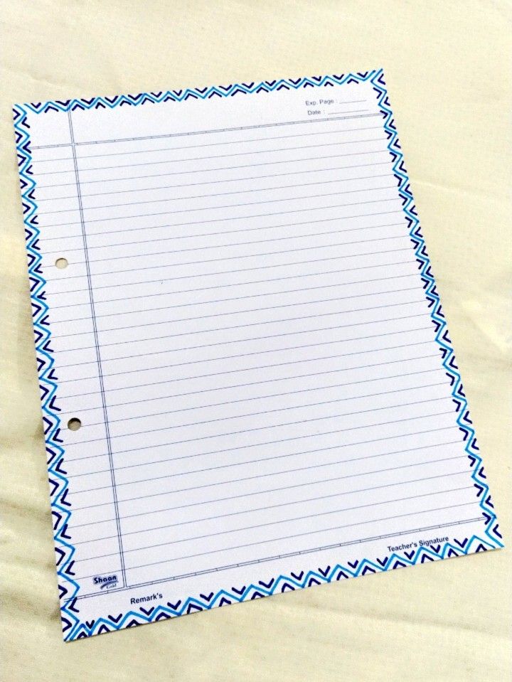 a piece of lined paper on top of a sheet of white paper with blue trim