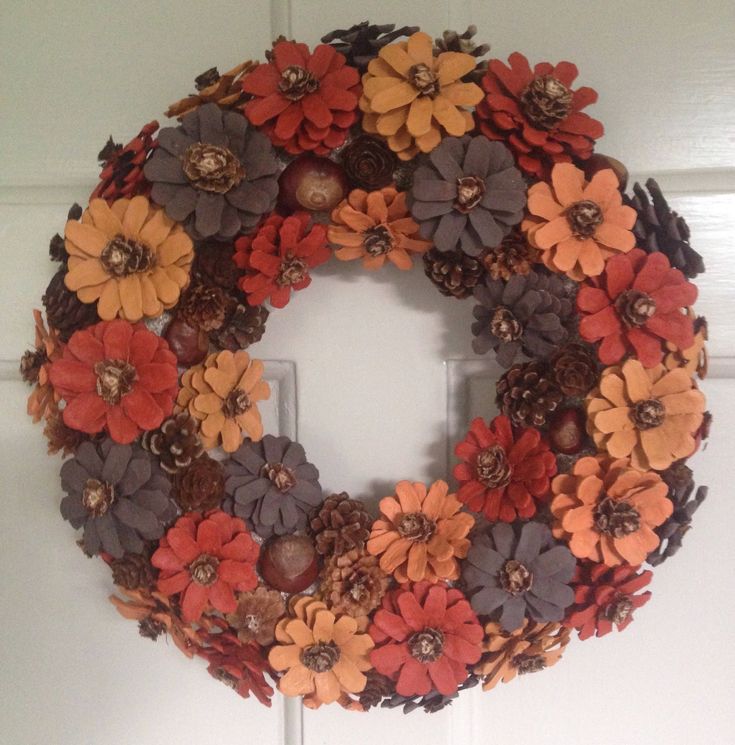 a wreath made out of fake flowers is hanging on the front door with a light switch