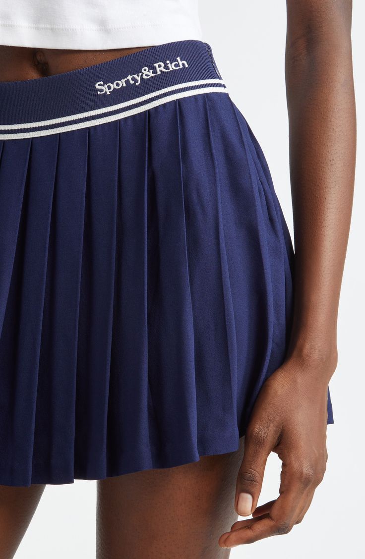 Sporty stripes and a logo embroidery highlight the waist of this preppy skirt boasting crisp allover pleats. Elastic waist 100% viscose Dry clean or machine wash, line dry Imported Asian & Pacific Islander Owned/Founded Navy Casual Tennis Skirt, Fitted Striped Skort With Pleated Skirt, Navy Pleated Flowy Skirt, Preppy Pleated Tennis Skirt, Classic Summer Tennis Skirt With Pleated Hem, Navy Pleated Skirt Bottoms For Spring, Classic Pleated Tennis Skirt For Summer, Navy Pleated Skort, Navy Pleated Mini Skirt