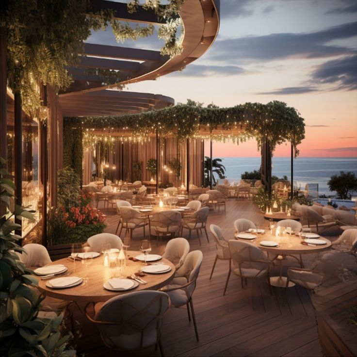 an outdoor dining area overlooking the ocean at dusk with lit candles on tables and chairs