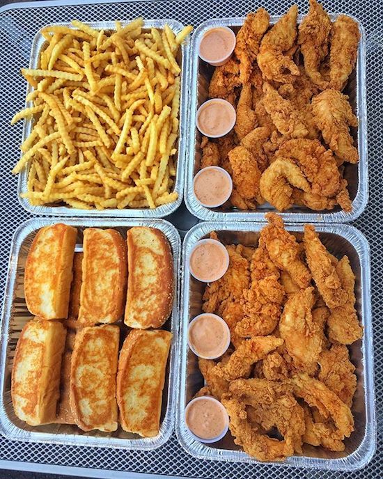 four plastic trays filled with different types of food