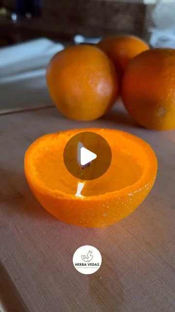 an orange is sliced in half and placed on a cutting board next to other fruit